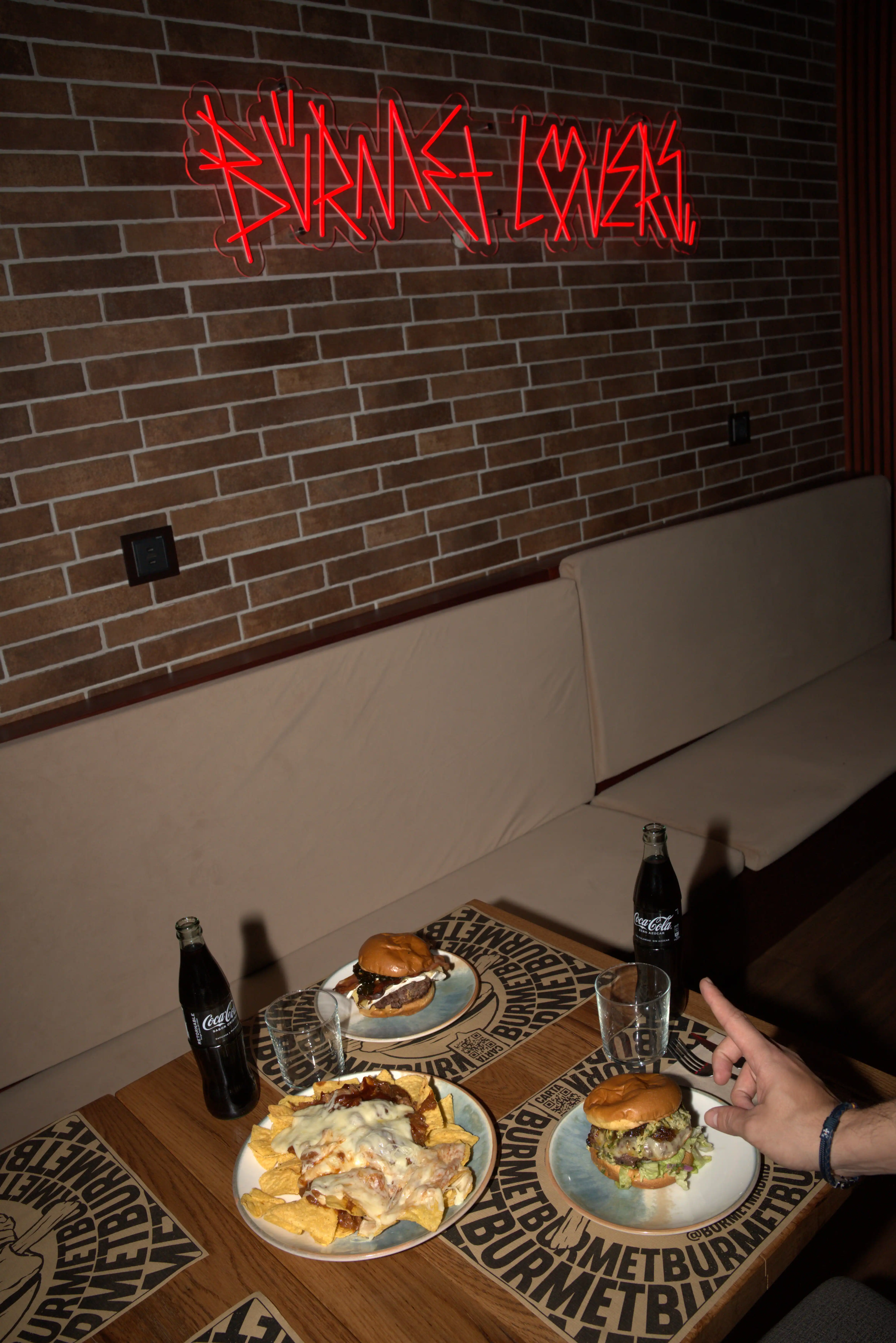 Mesa con hamburguesas y nachos en BURMET