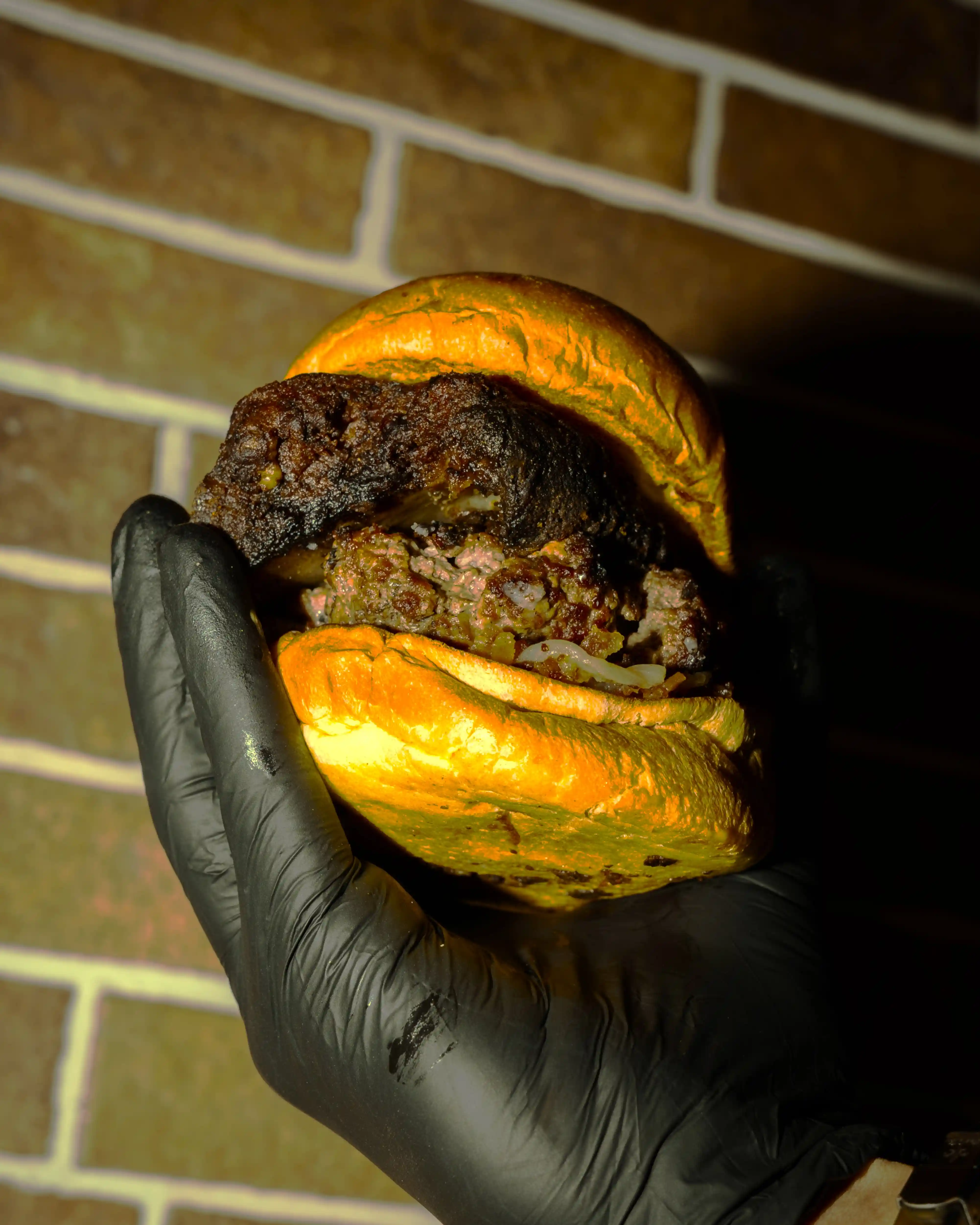 Hamburguesa Short Rib de BURMET sostenida en la mano