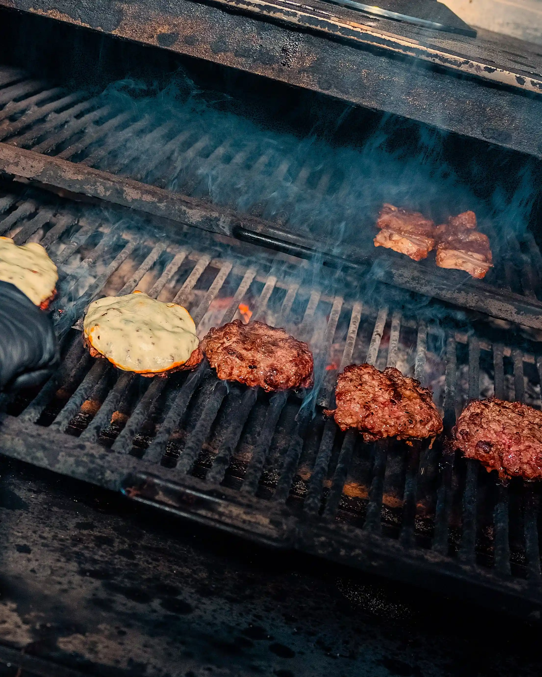 Hamburguesas cocinándose a la brasa en el Josper de BURMET Madrid